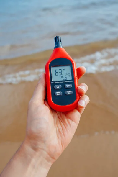 Termómetro portátil en mano que mide la temperatura y la humedad del aire exterior —  Fotos de Stock