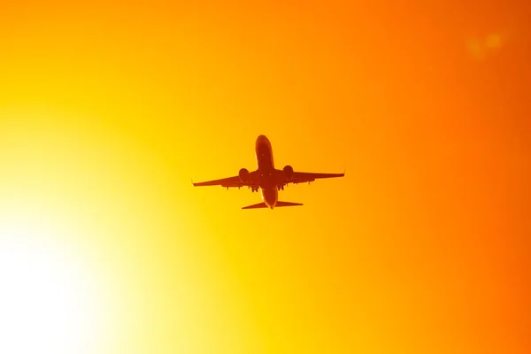 Flying airplane in the orange sky sunset — Stock Photo, Image