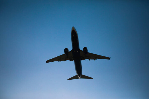 Flying airplane in blue sky dusk