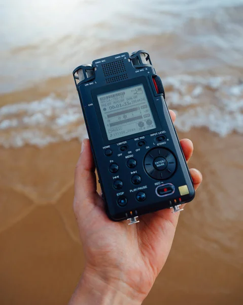 Registratore audio portatile in mano che registra i suoni ambientali del mare — Foto Stock