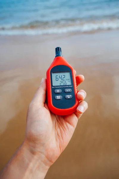 Thermomètre portable à la main mesurant la température et l'humidité de l'air extérieur — Photo