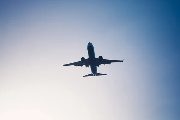 Silueta del avión volador en el atardecer cielo azul — Foto de Stock