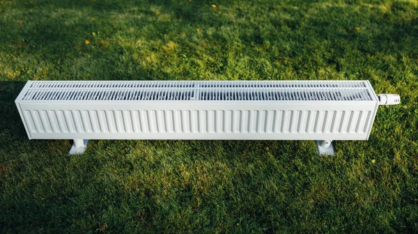 Radiator on green lawn, ecological heating concept — Stock Photo, Image