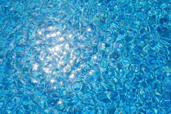 Water ripples texture in swimming pool with sunny glare — Stock Photo, Image