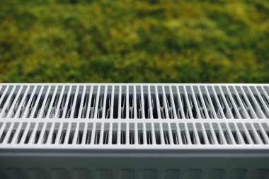 Radyatör kafes, yeşil çim arka plan, kavram Isıtma ekolojik
