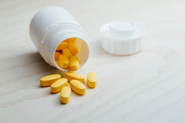 Nutrition supplements, yellow multivitamin pills — Stock Photo, Image