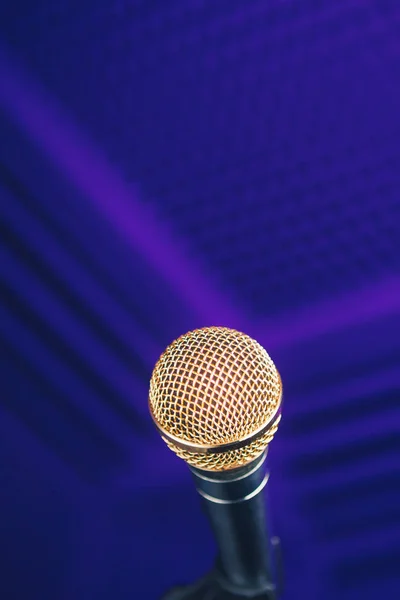 Micrófono dorado en el soporte, fondo púrpura con espuma acústica en el estudio — Foto de Stock