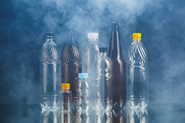Variedad de botellas de plástico en el humo, concepto de contaminación —  Fotos de Stock