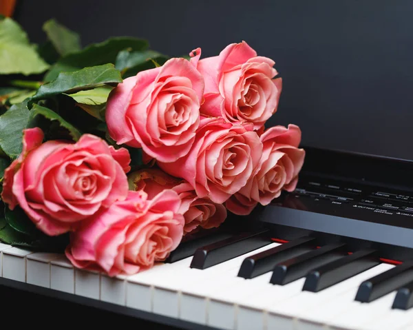 Bouquet di rose rosa sui tasti del pianoforte digitale — Foto Stock