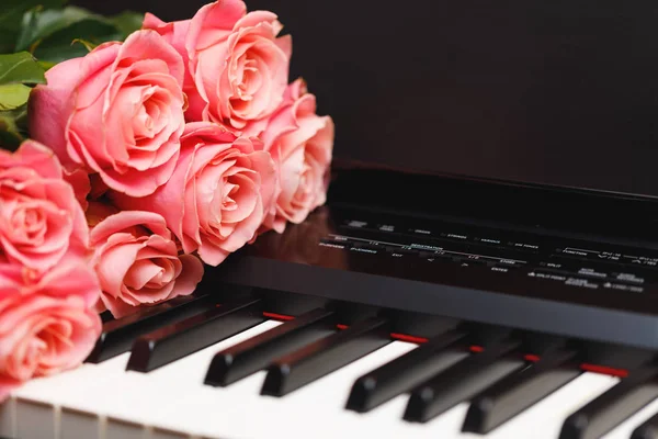 数码钢琴琴键上的粉红色玫瑰花束 — 图库照片