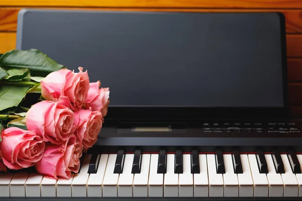 数码钢琴琴键上的粉红色玫瑰花束 — 图库照片