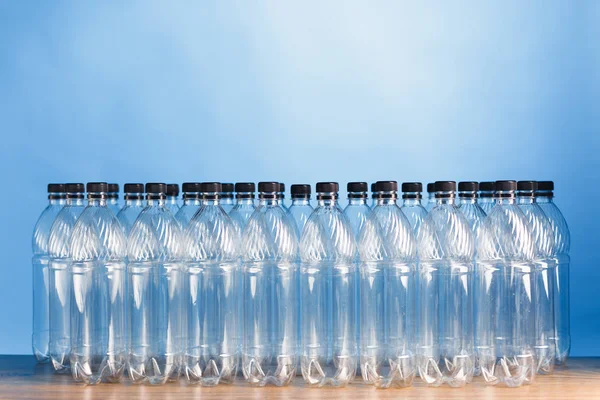 Empty plastic bottles on blue background — Stock Photo, Image