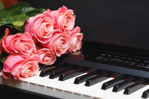 Букет рожевих троянд на цифрових клавішах піаніно — стокове фото