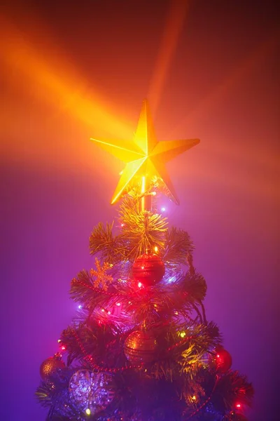 Árvore de Natal com luzes festivas, fundo roxo com névoa — Fotografia de Stock