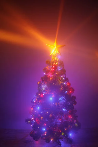 Vánoční stromek se slavnostními světly, fialové pozadí s mlhou — Stock fotografie