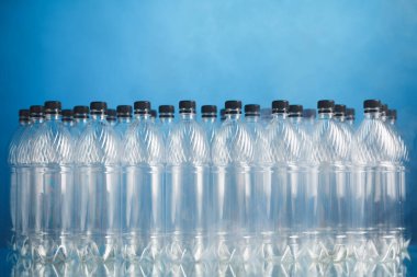 mavi arka plan üzerinde boş plastik şişeler