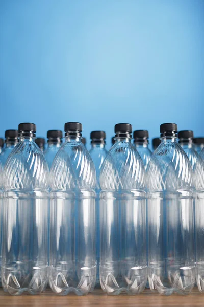 Üres műanyag palackok kék háttérrel — Stock Fotó