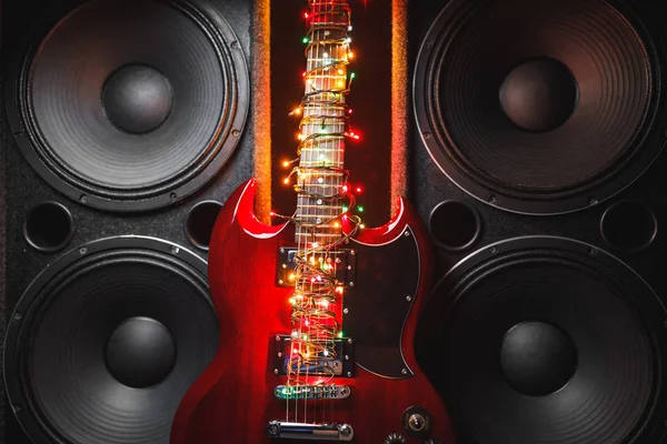 Elektromos gitár ünnepi karácsonyi fényekkel és hangszórókkal — Stock Fotó