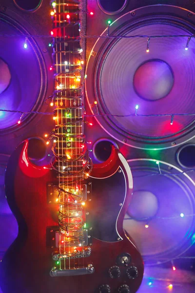 Electric guitar with festive Christmas lights and music speakers in smoke — Stock Photo, Image