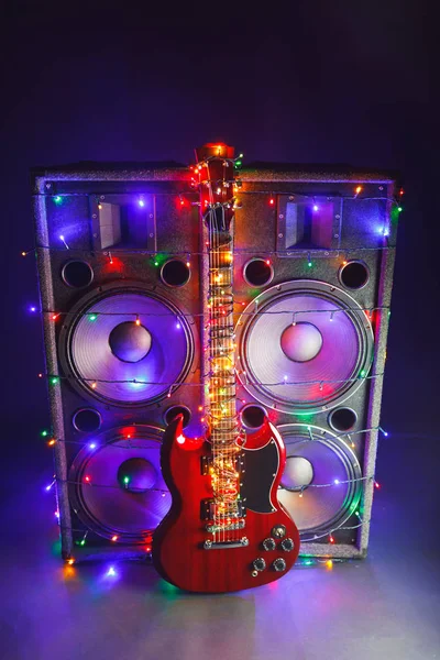 Guitarra eléctrica con luces navideñas festivas y altavoces de música —  Fotos de Stock