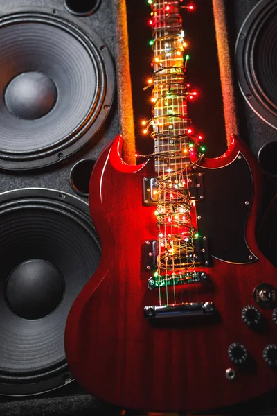 Guitarra eléctrica con luces navideñas festivas y altavoces de música — Foto de Stock