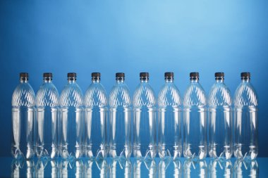 mavi arka plan üzerinde boş plastik şişeler