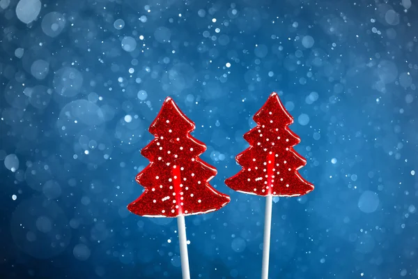 クリスマスツリーの赤い甘いキャンディー、雪のボケブルーの背景 — ストック写真