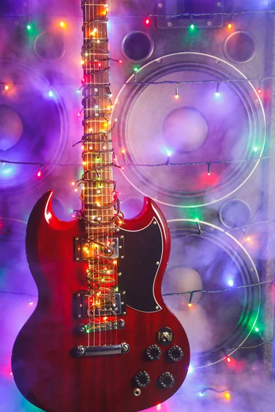 Elvont gitár ünnepi karácsonyi fényekkel és hangszórókkal füstben — Stock Fotó