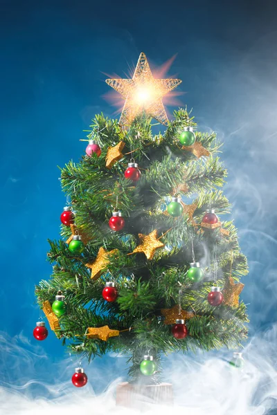 Kerstboom in ice mist, blauwe achtergrond — Stockfoto