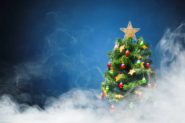 Kerstboom in ice mist, blauwe achtergrond — Stockfoto