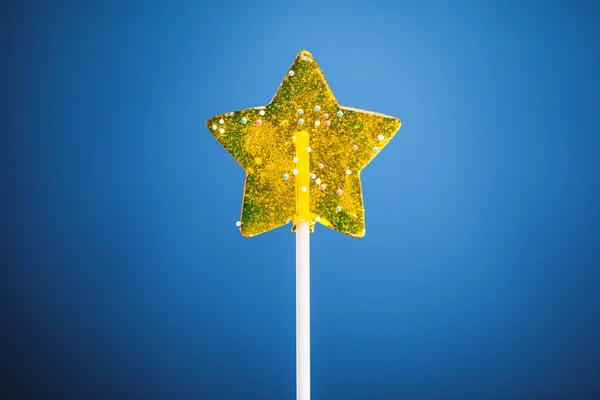 Caramelo estrella amarilla, fondo azul — Foto de Stock