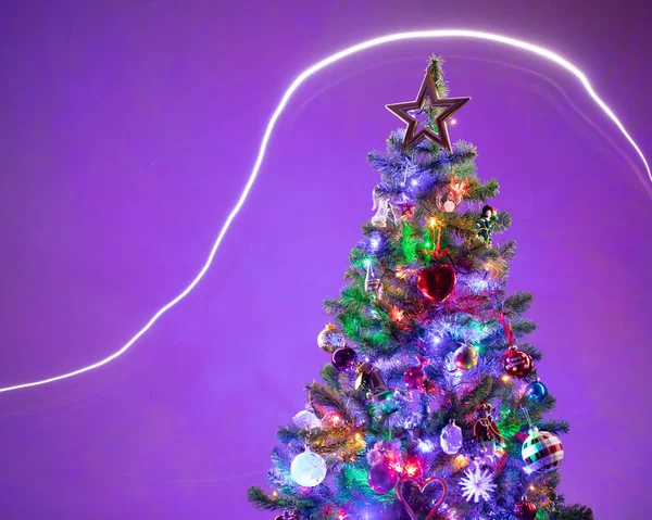 Christmas tree with multicolor led lights and purple background — Stock Photo, Image