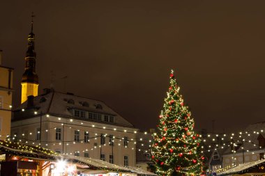 Süslemeleri ve ışıkları olan Noel ağacı, geceleri Avrupa Noel pazarı
