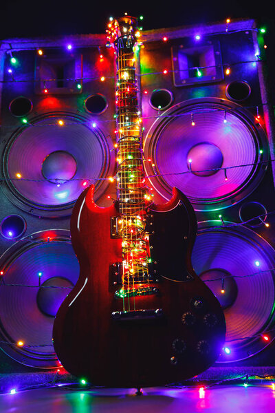 abstract guitar with festive Christmas lights and music speakers