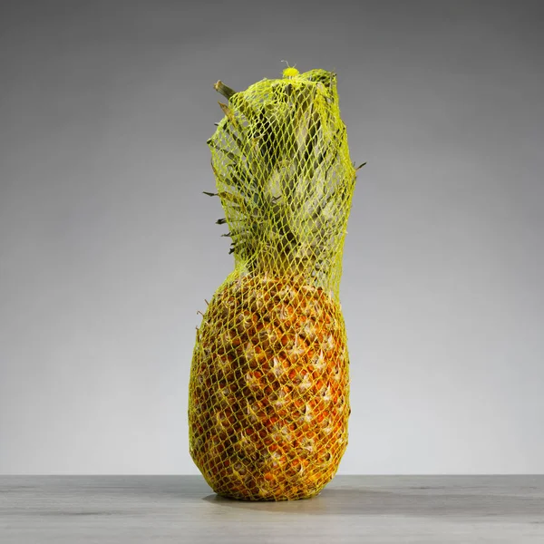 Ananas Förpackad Vid Transport Mesh Grå Bakgrund — Stockfoto