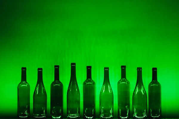 Elvont Üres Borosüvegek Zöld Megvilágítással — Stock Fotó
