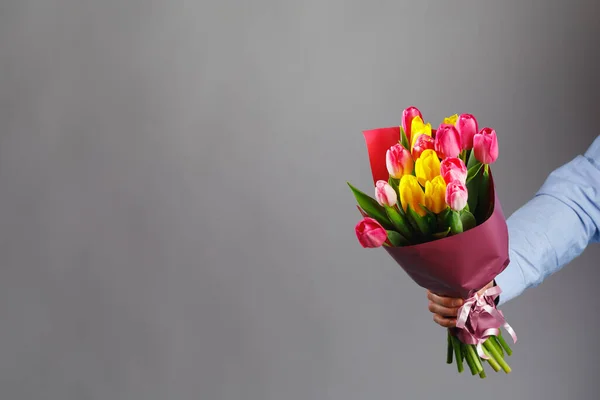 チューリップの花の花束を手に コピースペースと灰色の背景 — ストック写真