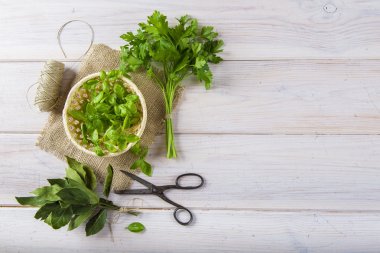 Taze fesleğen bir sepet ve bir demet maydanoz ve defne yaprağı