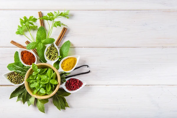 Friss fűszernövények és fűszerek a fehér fa háttér — Stock Fotó