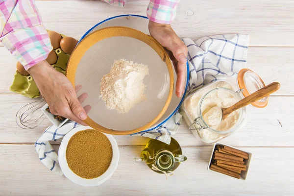 Cocinar mujer tamizar la harina con las manos — Foto de Stock