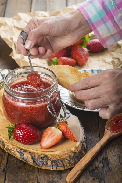 Aardbeienjam smeren op een toast voor het ontbijt — Stockfoto