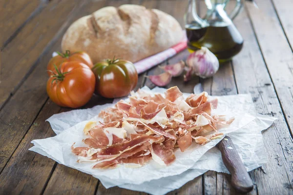 Kinkku leipää, tomaattia, valkosipulia ja oliiviöljyä — kuvapankkivalokuva