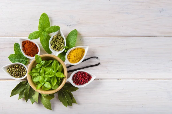 Fresh herbs and spices on a white wooden background — Stock Photo, Image