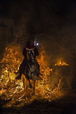 A man riding his horse jumping throug the fire clipart