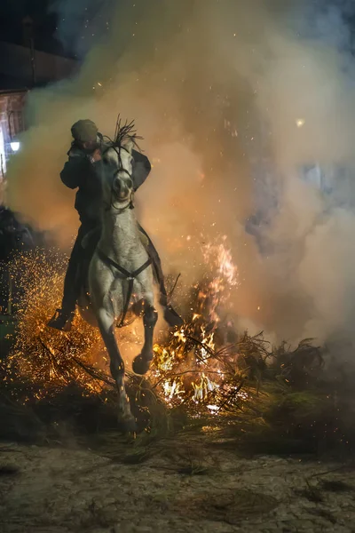Un hombre montando su caballo saltando a través del fuego — Foto de Stock