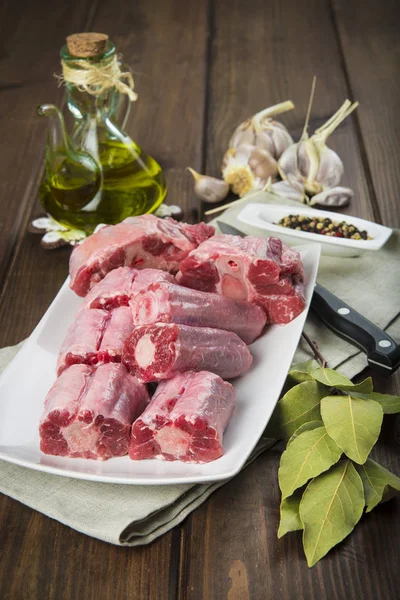 Oxtail and with olive oil and ingredients to cook it — Stock Photo, Image