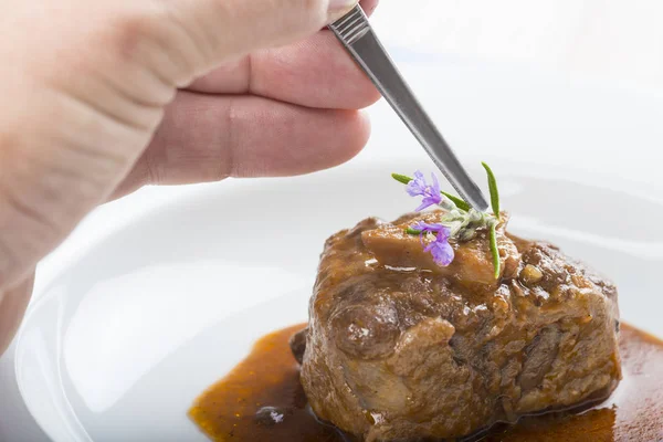 Estilista de alimentos trabajando en una placa de estofado de cola de buey — Foto de Stock