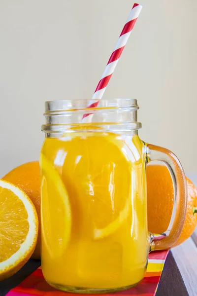 Orange juice in a mason jar with a drinking straw — Stock Photo, Image