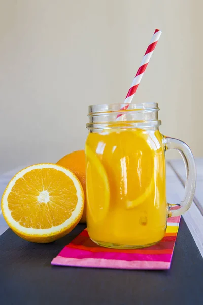 Апельсиновый сок в банке каменщика с соломинкой — стоковое фото