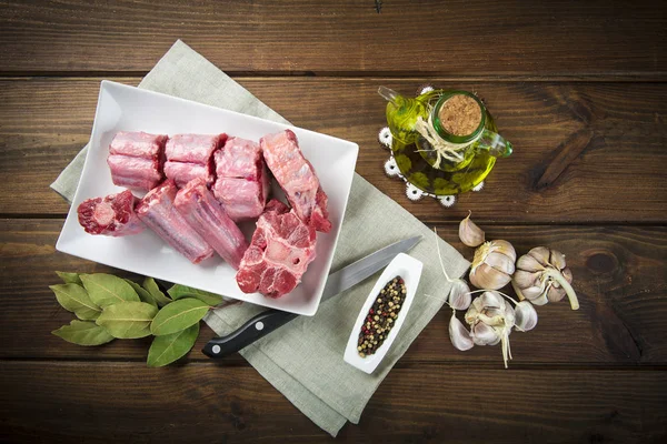 Oxtail and with olive oil and ingredients to cook it — Stock Photo, Image